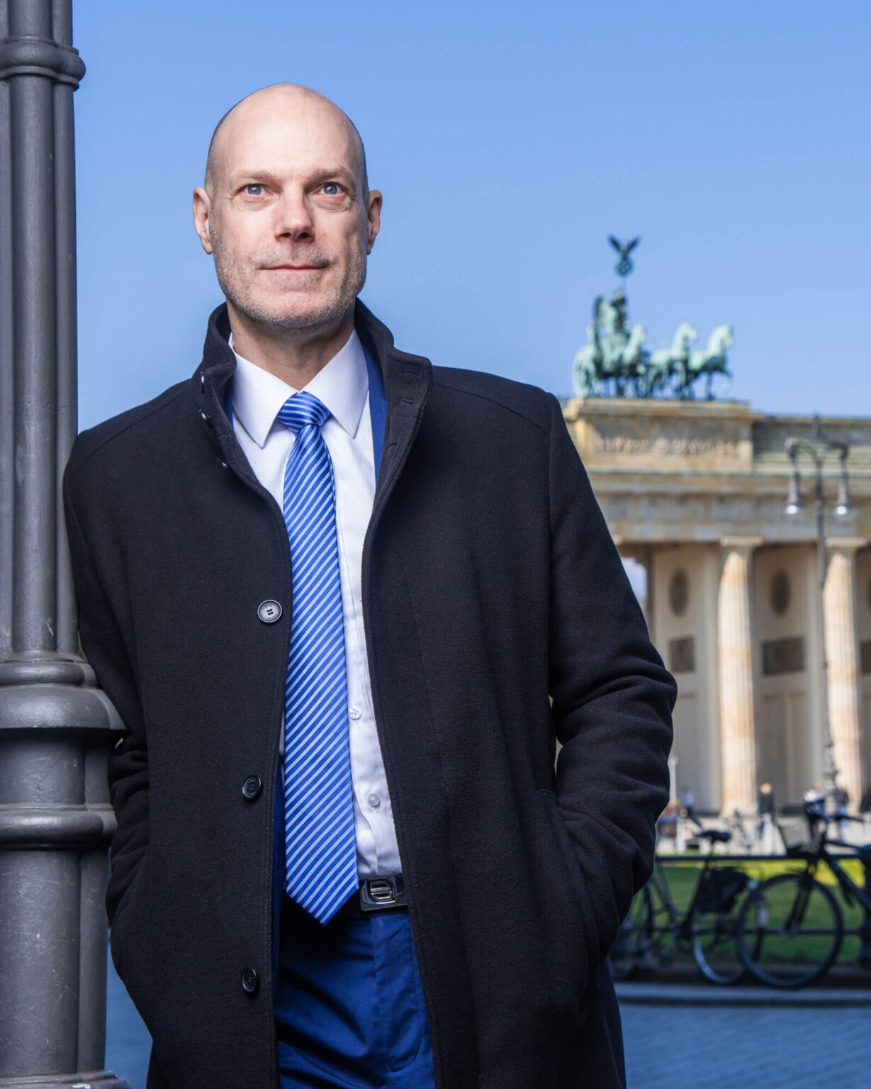 Sven Wendorf lehnt an einer Laterne vor dem Brandenburger Tor in Berlin.